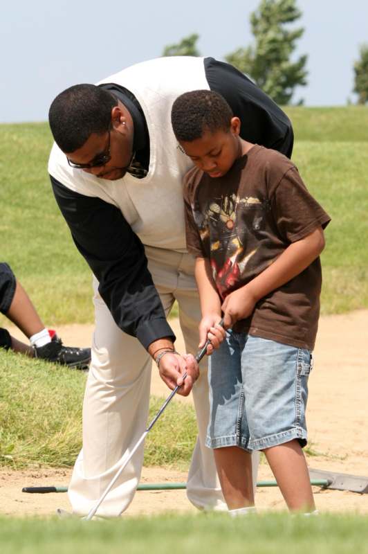a man and boy holding a golf stick