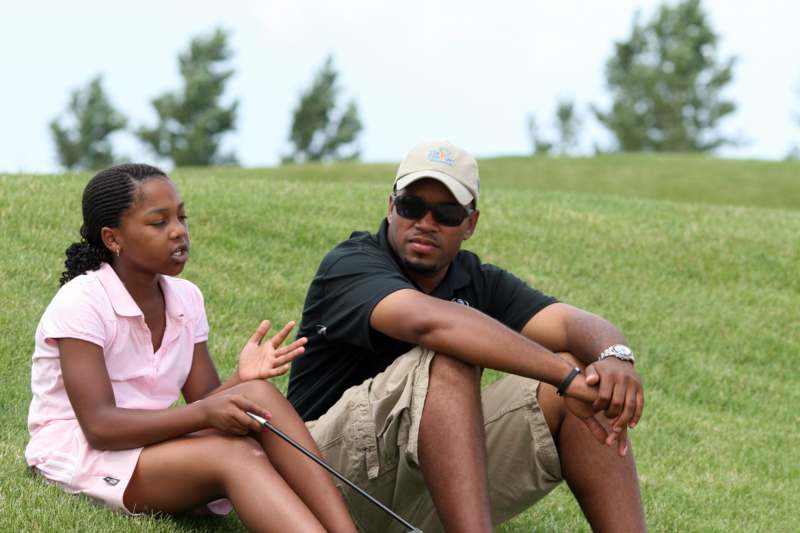 a man and a girl sitting on grass