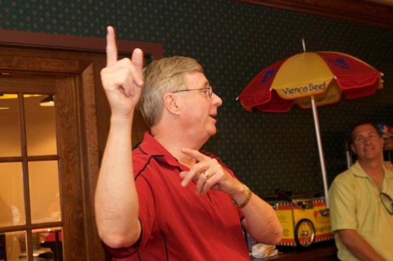 a man in a red shirt pointing up