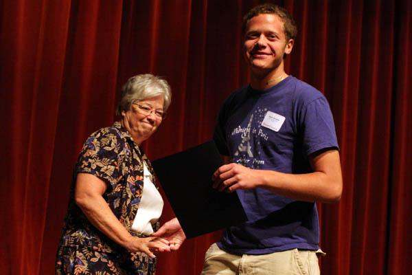 a man holding a black piece of paper next to a woman