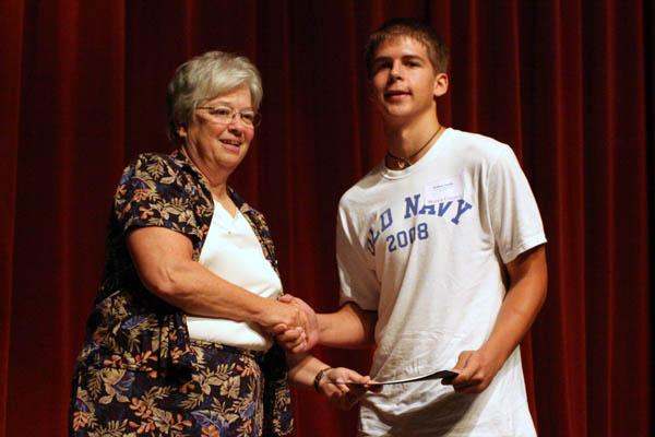 a woman shaking hands with a young man