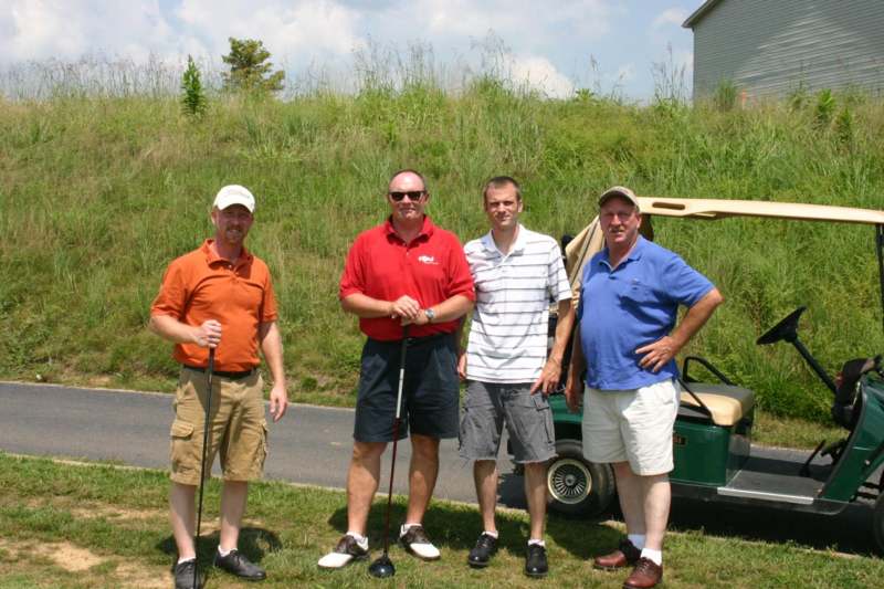 a group of men standing in a golf course