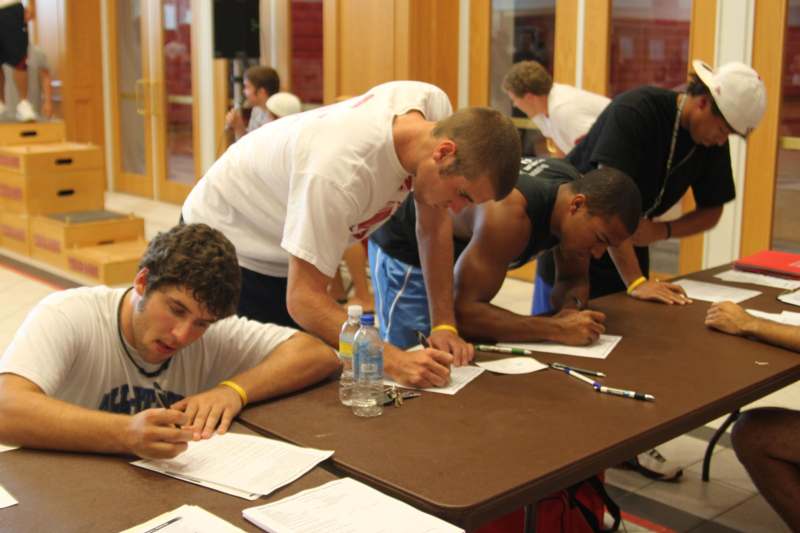 a group of men writing on papers