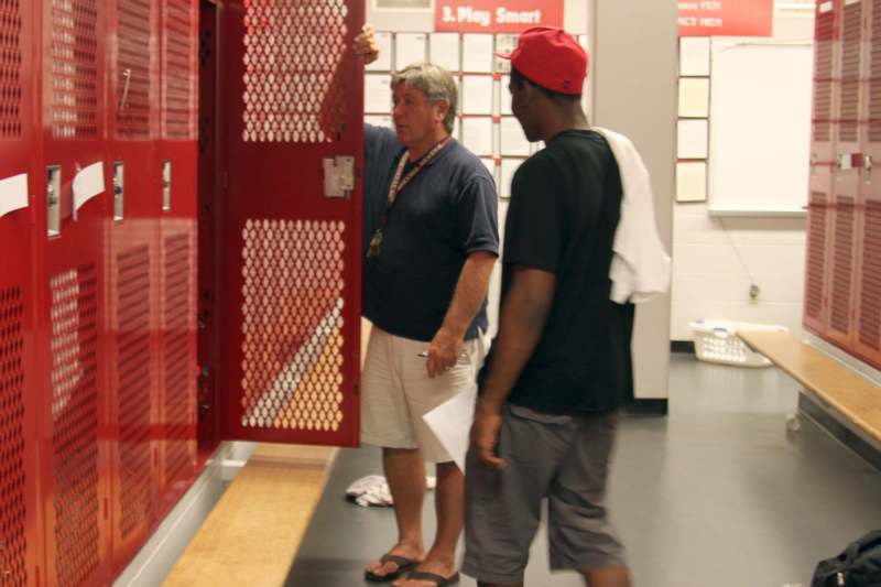 a man standing next to a man in a red hat