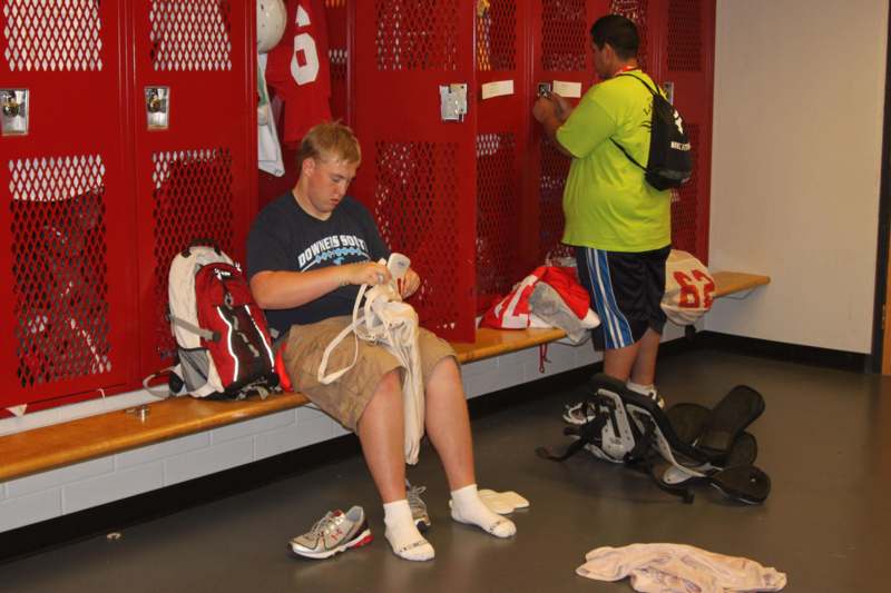 a man sitting on a bench in a locker room