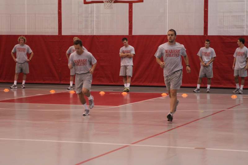 a group of men in grey shirts on a gym floor
