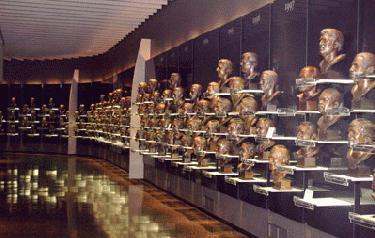 a row of bronze heads on shelves