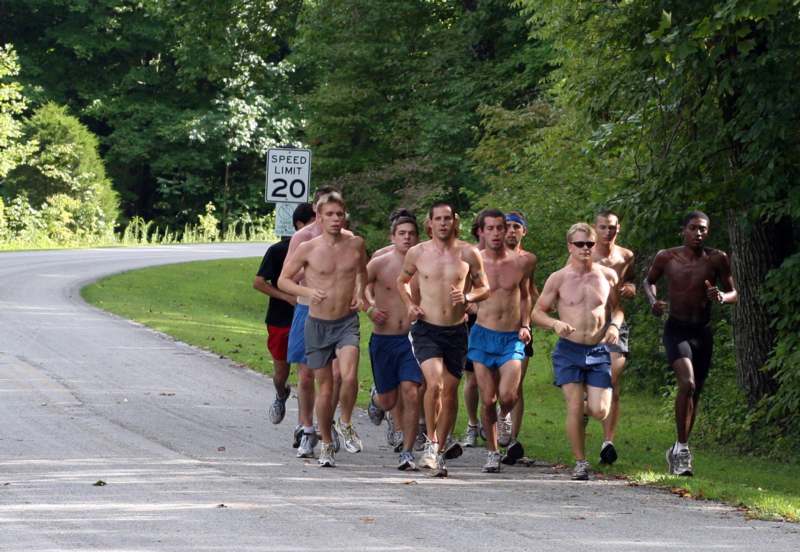 a group of men running on a road