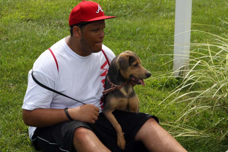 a man sitting on grass with a dog
