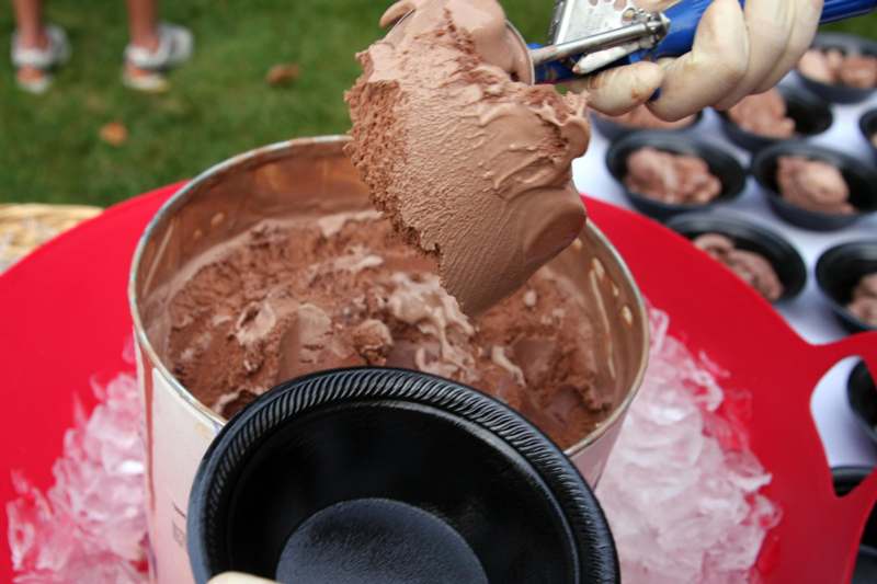 a person scooping chocolate ice cream