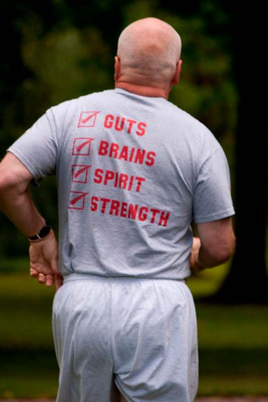a man wearing a grey shirt with red writing on it