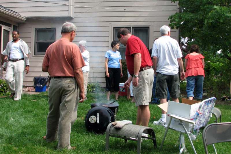 a group of people standing around a barbecue