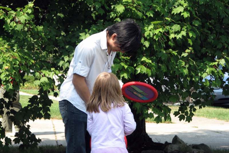 a man and a girl playing with a frisbee