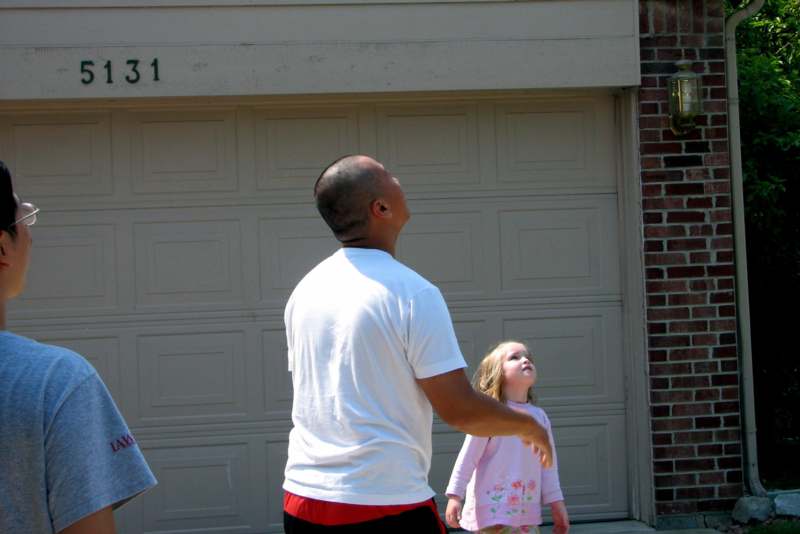 a man and a girl standing in front of a garage door
