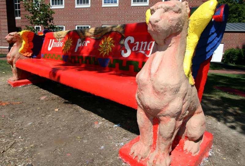 a red bench with a statue of a lion