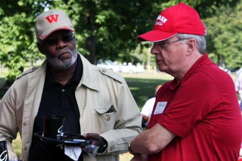 men in red hats talking to a man