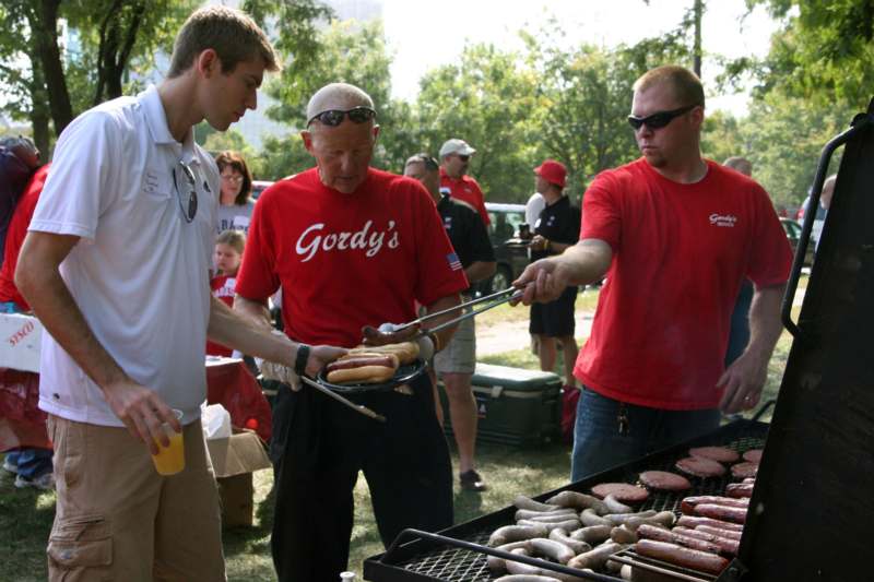 a group of men grilling hot dogs
