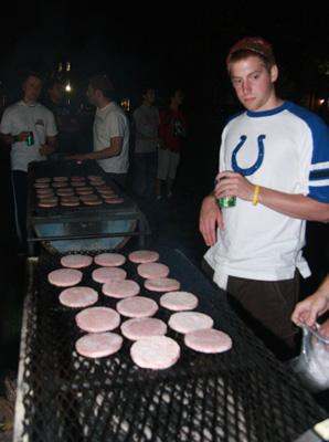 a man cooking burgers on a grill
