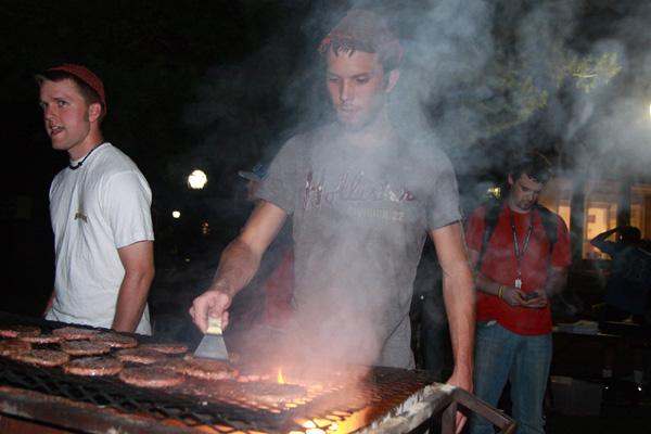 a man grilling burgers at night