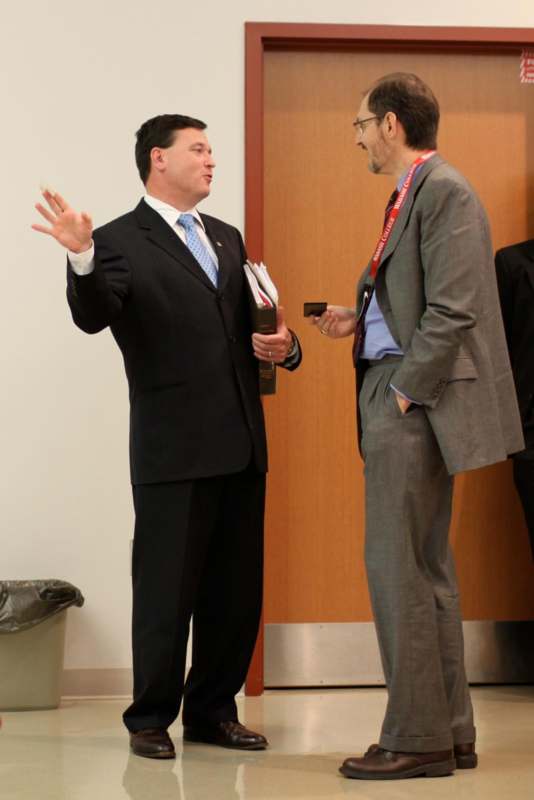 a man in a suit talking to another man