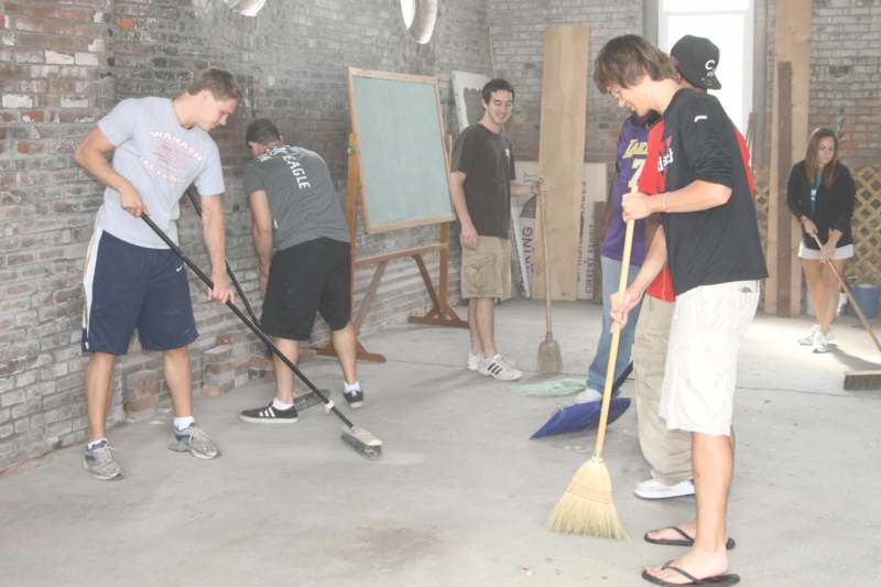 a group of young men cleaning in a room