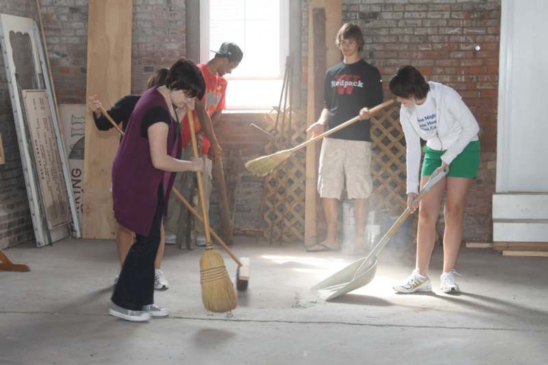a group of people sweeping the floor