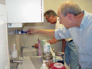 men painting a bathroom sink