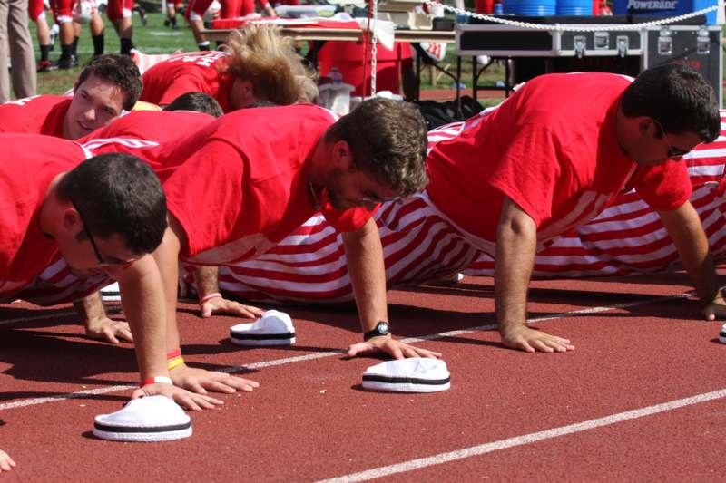 a group of people doing push ups on a track