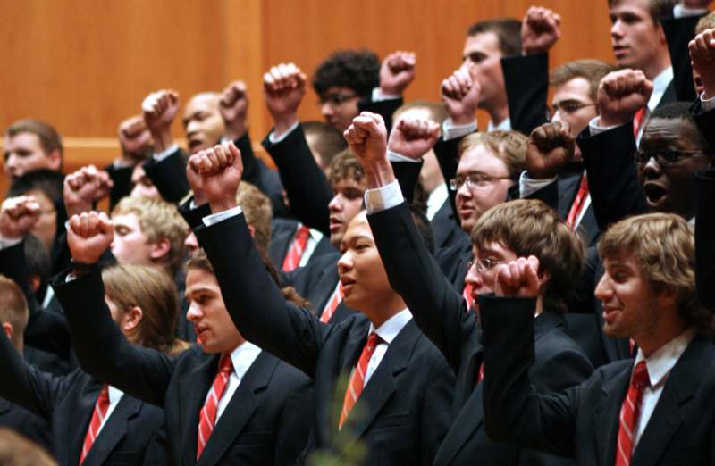 a group of people in suits raising their fists