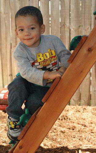 a boy climbing a wooden ladder