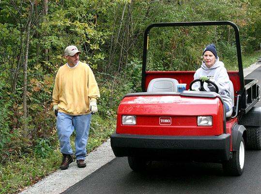 a man and woman in a golf cart
