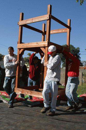 a group of men carrying a wooden structure