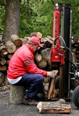 a man using a machine to cut logs
