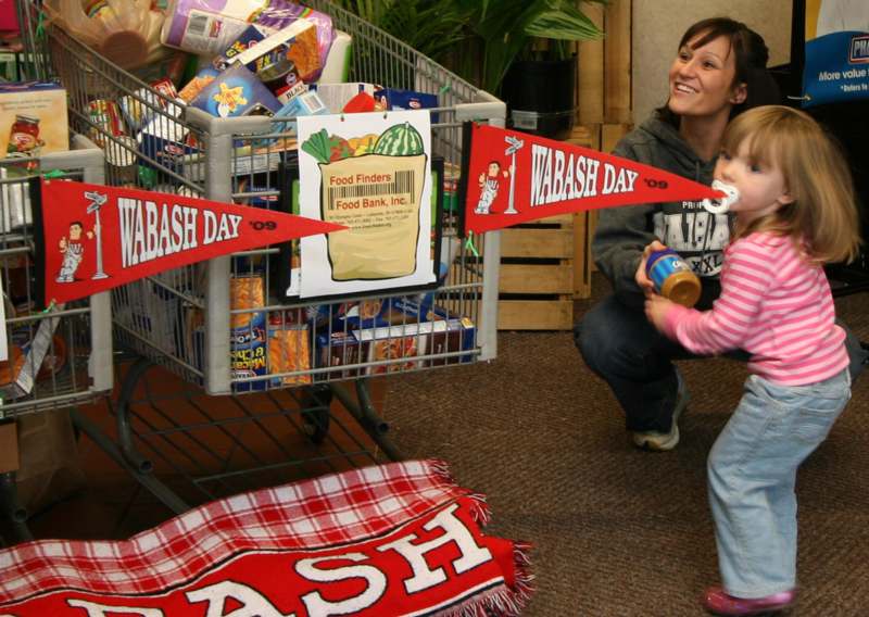 a woman and child playing with a shopping cart