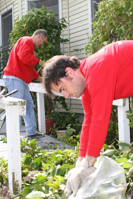 a man in red shirt working in a garden