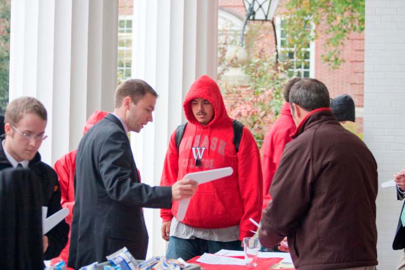 a man in a red hoodie standing next to a man in a red hoodie