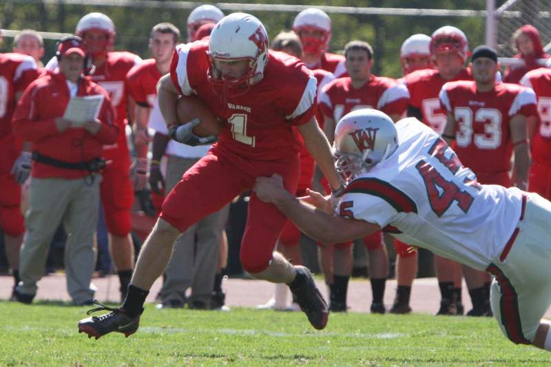 a football player in red running with another football player in the background