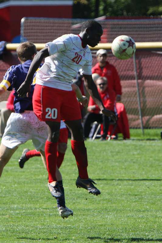 a man in red shorts kicking a football ball