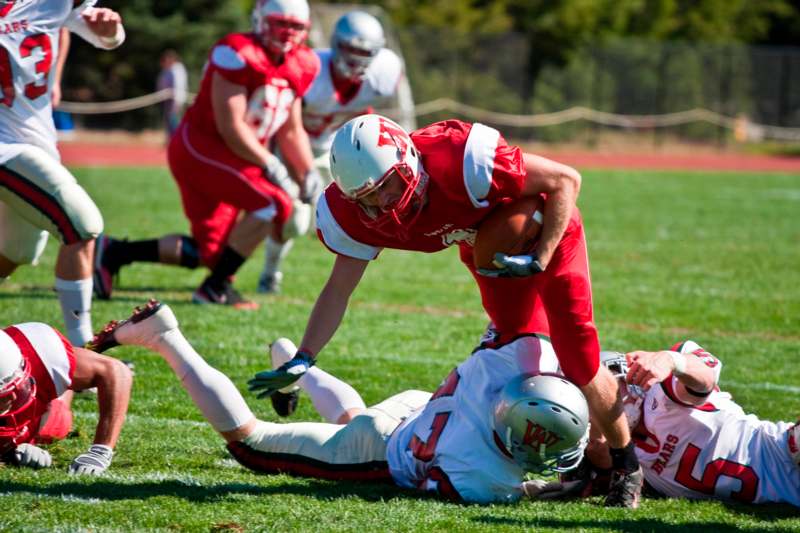a football player falling over another football player