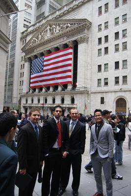 a group of men standing in front of a building with a flag