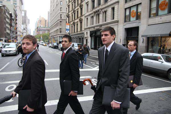 a group of men in suits walking on the street