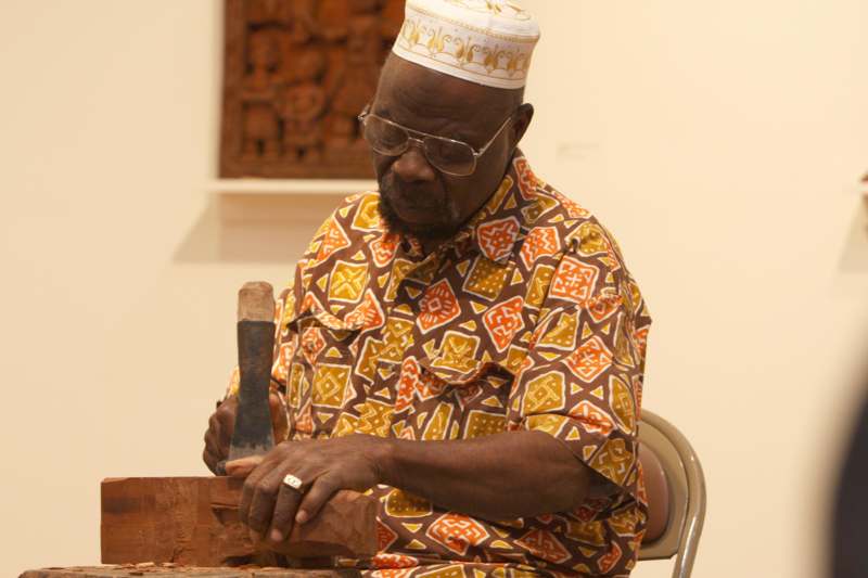 a man carving a piece of wood