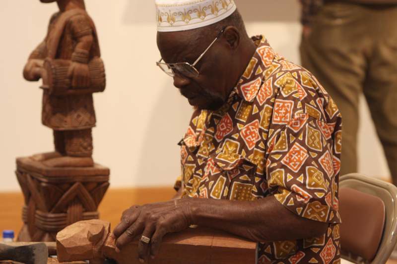 a man carving a wood