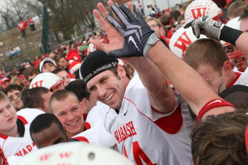 a football player with his hands up in the air