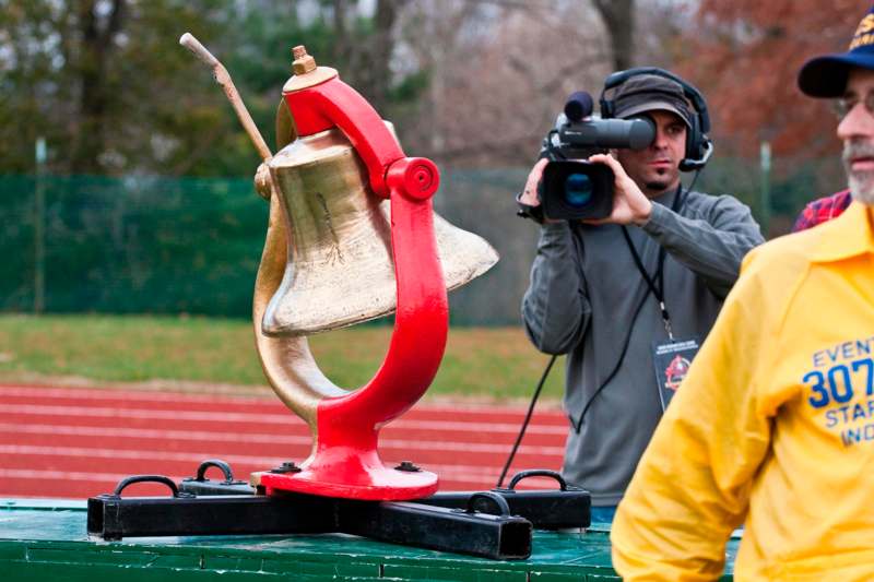 a man taking a picture of a bell statue
