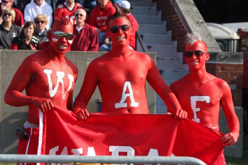 a group of people wearing red body paint holding a red flag