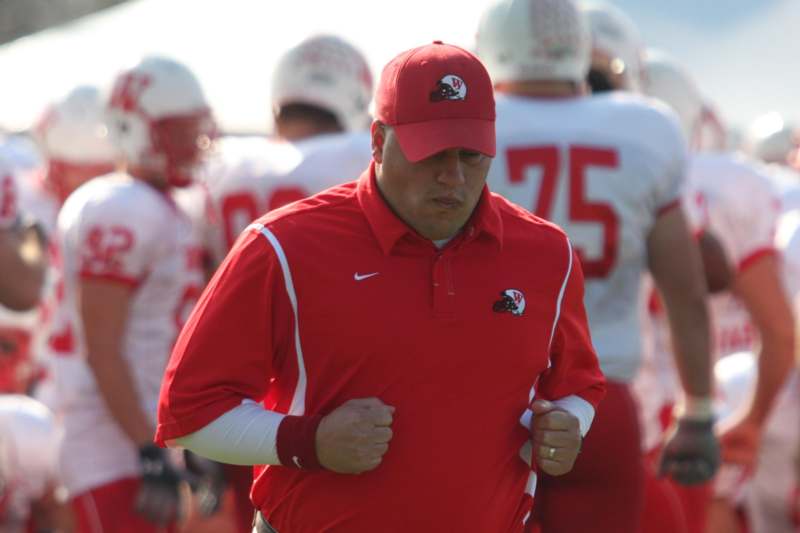 a football coach running with his players