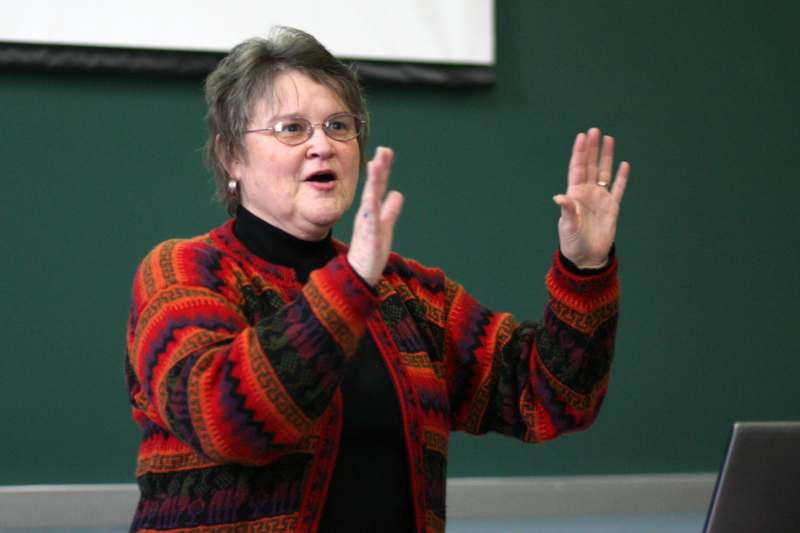 a woman in a red sweater with her hands up