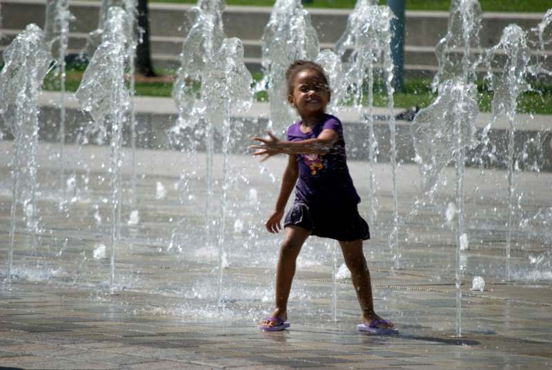 a girl playing in a fountain