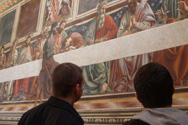 a group of people looking at a painting